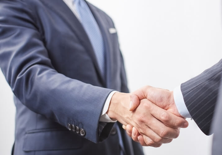 事務所案内の写真:男性二人が握手をしている